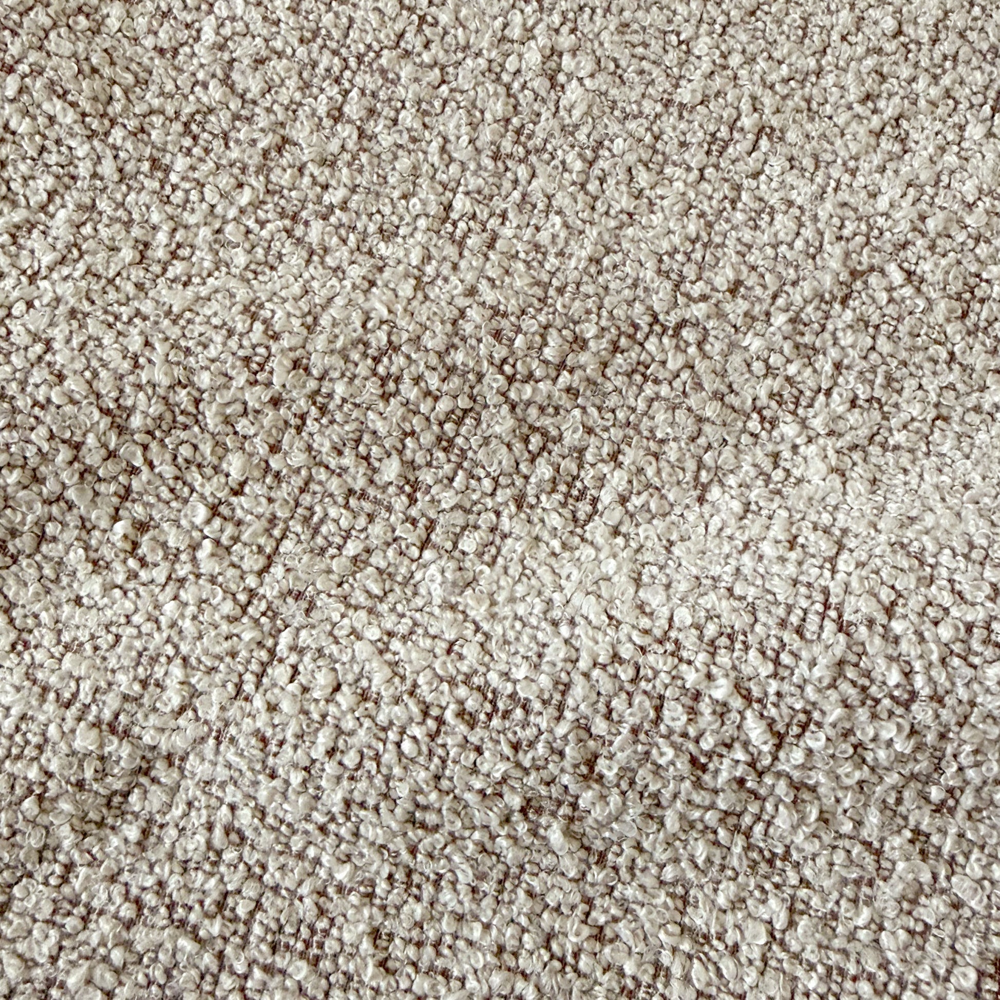 Close-up of warm beige boucle fabric texture with woven looped yarn pattern