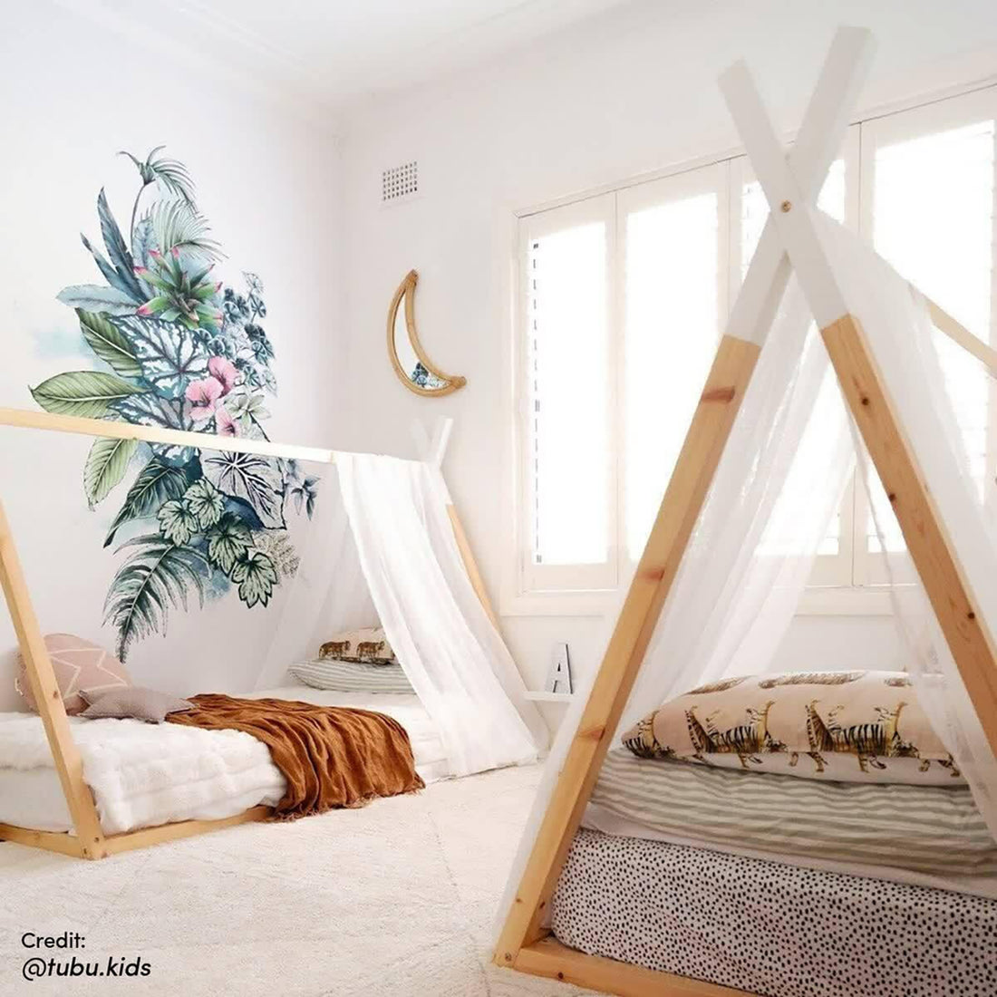 Helena Kids Single Solid Pine Teepee Bed Frame in Natural with light wood A-frame, sheer white drapes, and playful design. Features a low structure for easy access in a cozy children's bedroom.