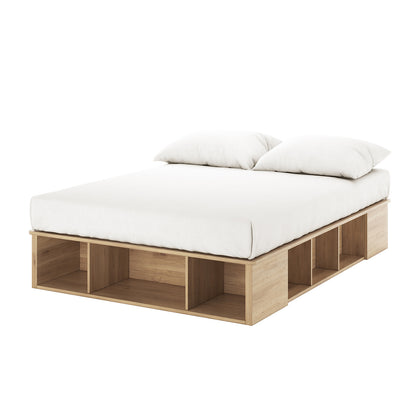 Herais Double Platform Bed Base with Storage in Oak features a minimalist light-wood frame with built-in cubby shelves and a white mattress, showcasing sleek design and smart storage functionality.