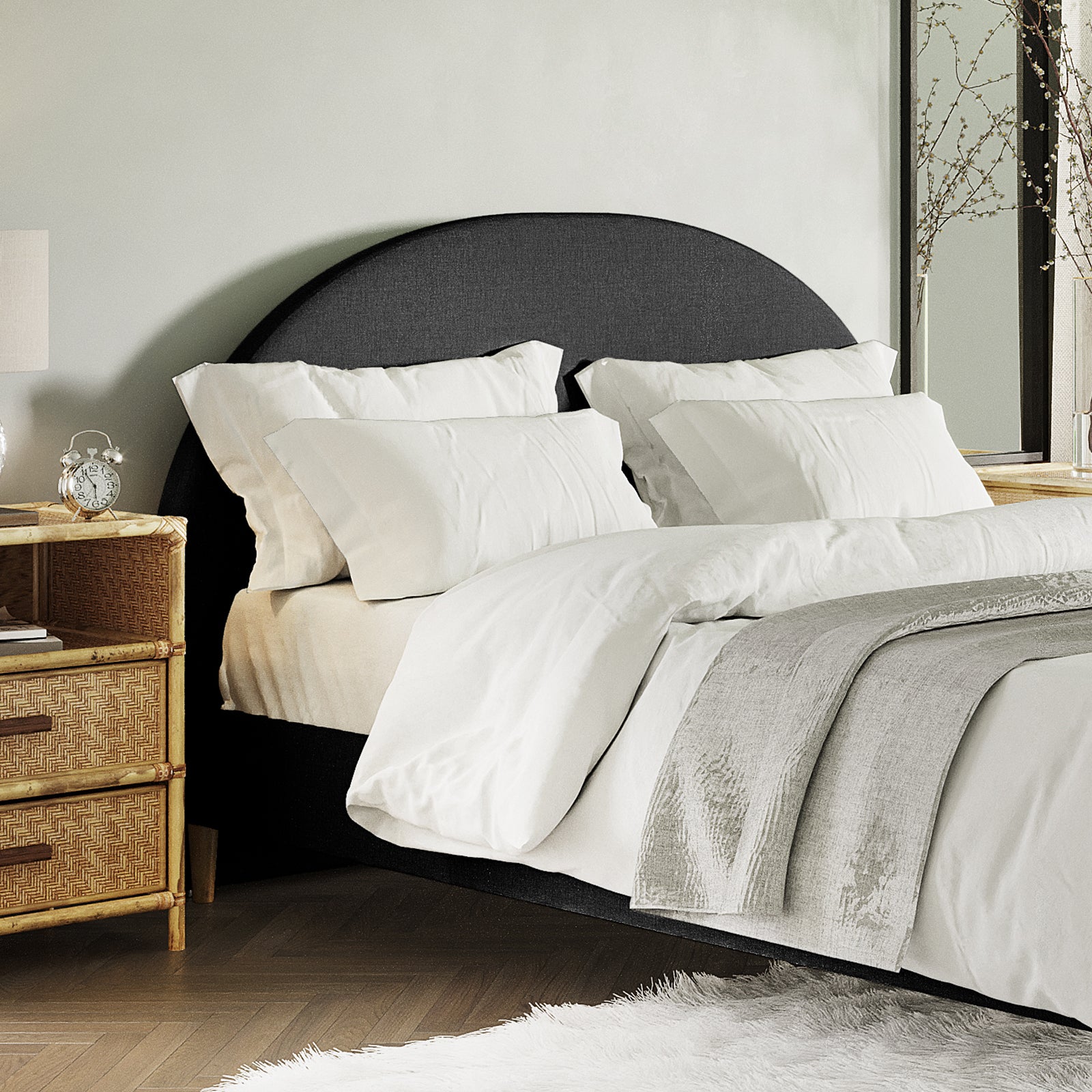 Florus Queen Arched Bouclé Fabric Headboard in Black features prominently with its curved silhouette and plush upholstery, set against a backdrop of crisp white bedding and a stylishly arranged bedroom corner.