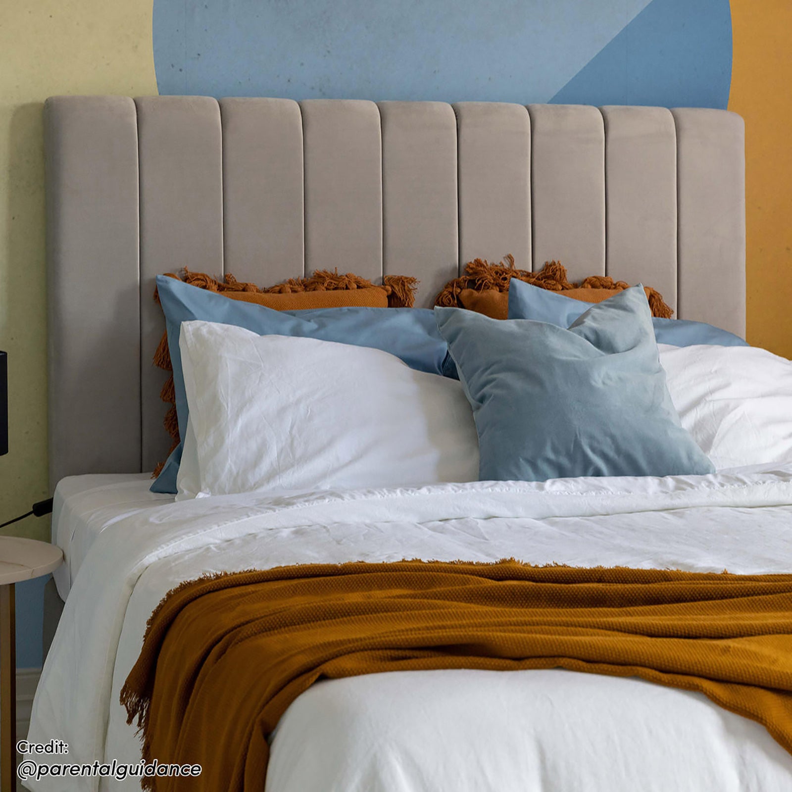 Gratiana Queen Velvet Fabric Headboard in Slate featuring a tall, vertically-tufted design with plush upholstery, framed by layered pillows and crisp white bedding, highlighting its sophisticated and versatile elegance.