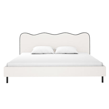 Kaylie King Boucle Fabric Bed Frame in White & Black features a scalloped headboard with dark piping, upholstered in off-white fabric, on slim dark legs, dressed with a white mattress cover and pillows.