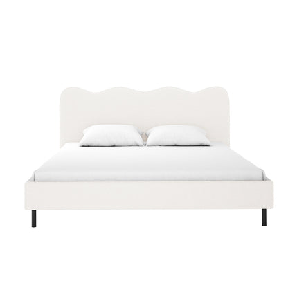 Kaylie Queen Boucle Fabric Bed Frame in Cream White features a wavy-top headboard, off-white upholstery, and slender black metal legs, dressed in white bedding, embodying minimalist elegance and functionality.