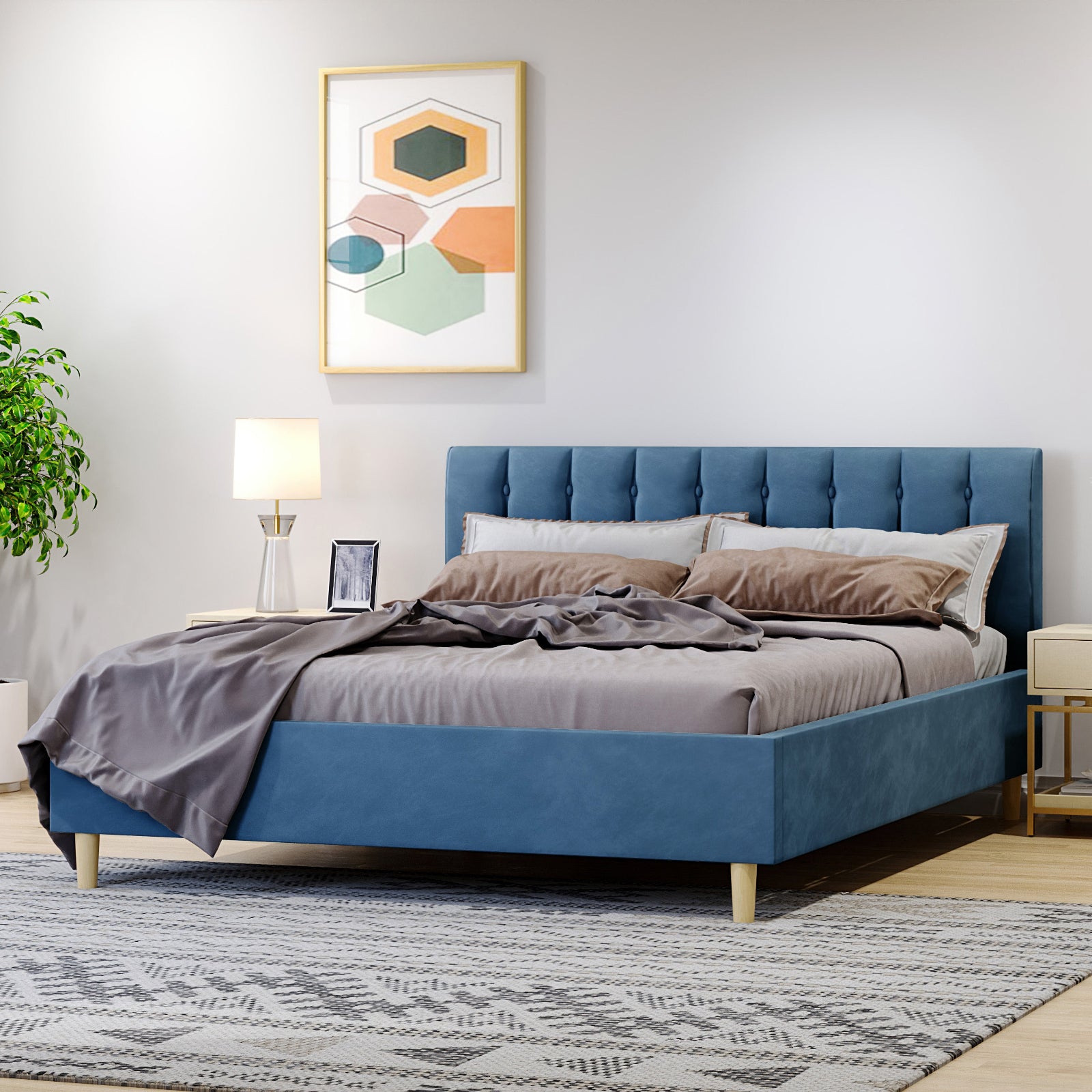Kelly Velvet Bed Frame - Queen (Ocean Blue) featuring a plush, rectangular headboard with vertical tufting, complemented by elegant tapered legs against a bedroom setting with a lamp and picture frame.