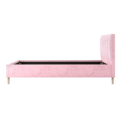 Kelly Single Velvet Fabric Bed Frame in Pink features a tall, channel-tufted headboard, matching side and foot rails, and light-wood legs, showcasing luxurious velvet upholstery without a mattress.