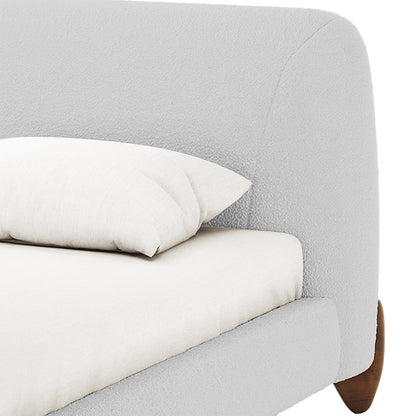 Laryn Queen Plush Bouclé Cloud Bed Frame in Light Grey features a boucle-style headboard, white mattress, pillow, and visible tapered wooden leg, highlighting its modern, sophisticated design and low-profile appeal.