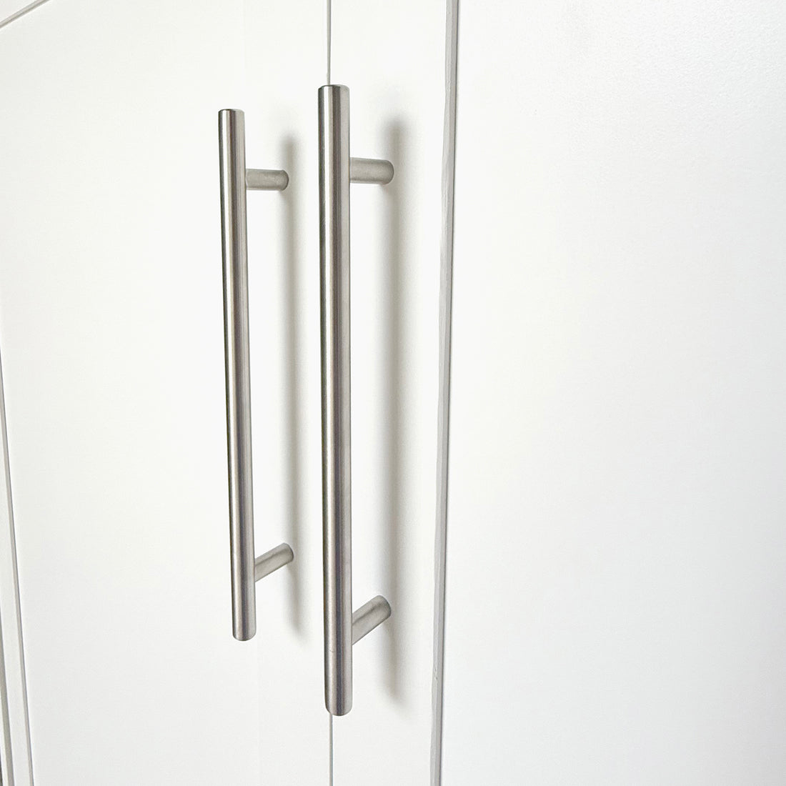 Leeton Space-Saving Queen Foldout Wall Bed White with brushed-steel T-bar handles on closed wardrobe doors, showcasing its sleek, modern design suitable for efficient space utilization.