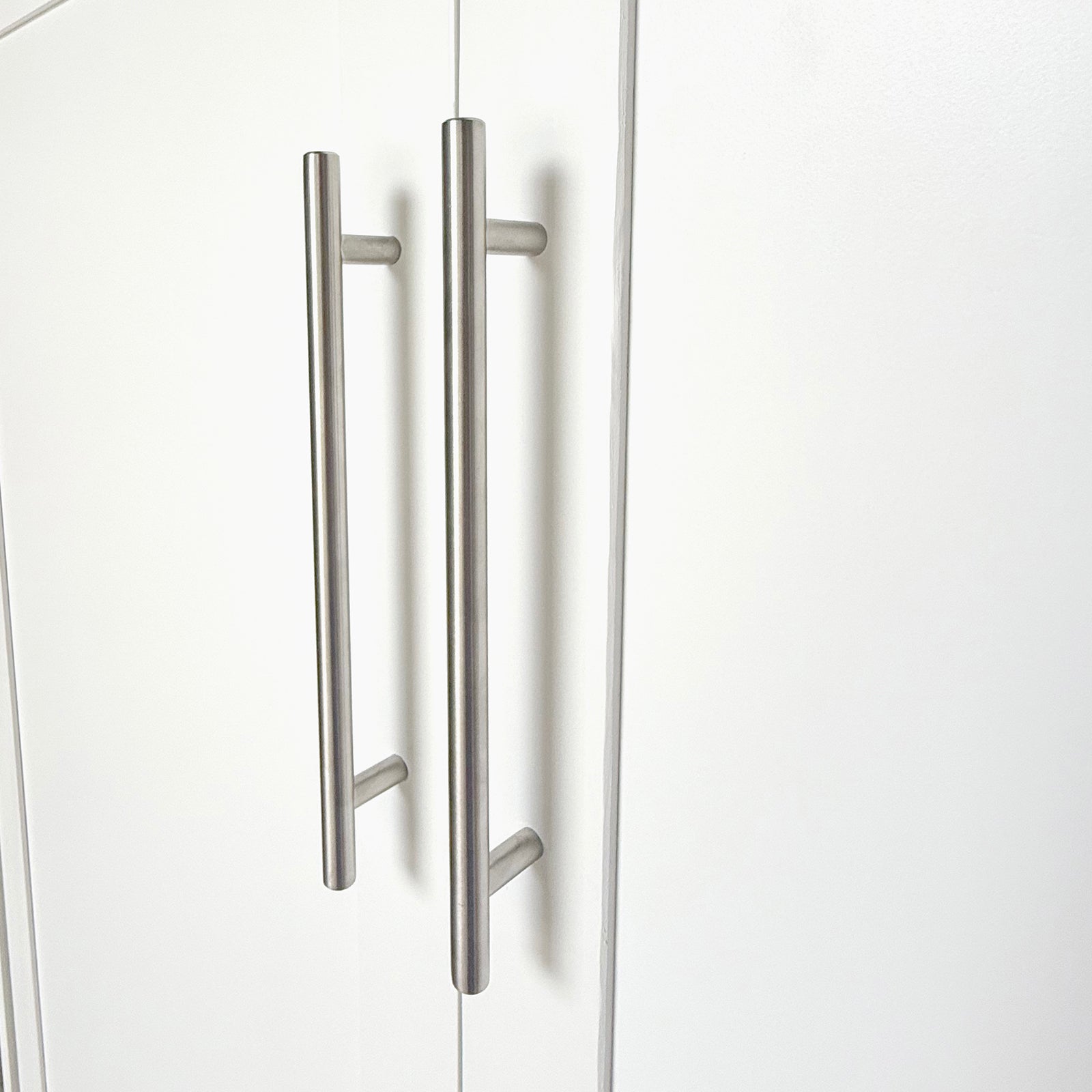 Leeton Space-Saving Queen Foldout Wall Bed White with brushed-steel T-bar handles on closed wardrobe doors, showcasing its sleek, modern design suitable for efficient space utilization.