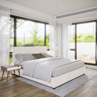 Lovita King Bouclé Bed Frame with Gas Lift Storage features a low-profile design, cream-white bouclé fabric, and a puffy headboard, set centrally in an airy bedroom with minimalist decor.
