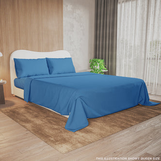 Valeria Single 1000TC Ultra Soft Bed Sheet Set in Blue on a queen bed with a curved white headboard, set against a wood-paneled wall, complemented by a nightstand and a leafy plant.