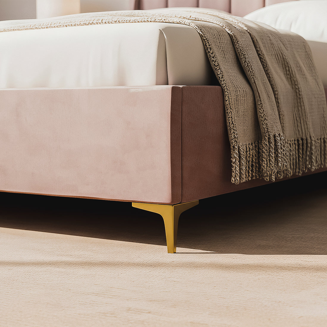 Close-up of the Lyra Queen Winged Velvet Fabric Bed Frame in Soft Pink, showcasing dusty-rose velvet upholstery, a white mattress, oatmeal-colored throw, and gold-toned metal leg on a light wood floor.