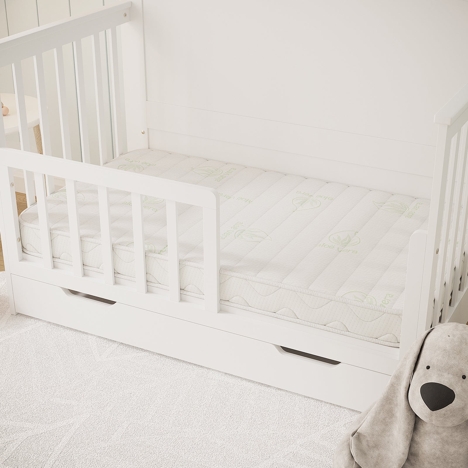 Gettel 10cm High-Density Foam Knitted Nursery Cot Mattress on a white wooden toddler-bed with aloe-infused cover, featuring a safety rail, pull-out drawer, and gray stuffed-animal dog. INPAA approved logo visible.
