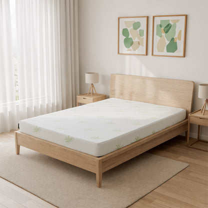 Junior Single 15cm Foam Mattress in Medium Firm rests on a minimalist wooden platform bed, featuring a subtle leaf-patterned cover. The setup includes matching nightstands, abstract wall art, and sheer curtains.