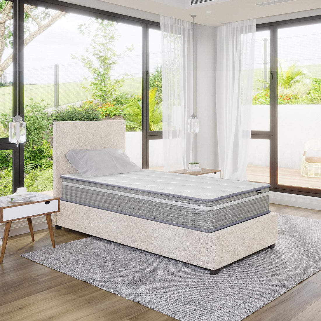 Oriona Single 25cm Pocket Spring Gel Mattress in Medium Firm displayed on a twin-size upholstered platform bed, featuring a two-tone design, with natural light streaming through floor-to-ceiling windows.
