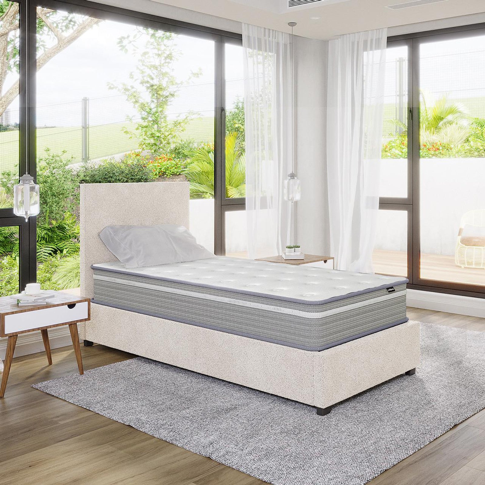 Oriona Single 25cm Pocket Spring Gel Mattress in Medium Firm displayed on a twin-size upholstered platform bed, featuring a two-tone design, with natural light streaming through floor-to-ceiling windows.