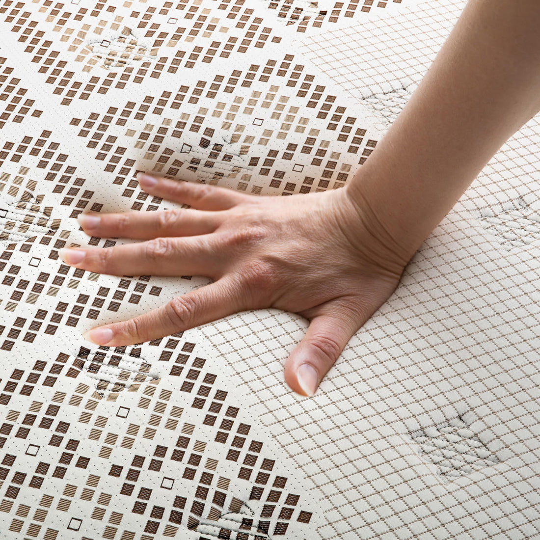 Hand pressing into the Thalia Double 30cm Memory Foam Pocket Spring Mattress, showcasing its medium firm feel and grid-patterned cover, highlighting the mattress's pressure-relieving and supportive properties.