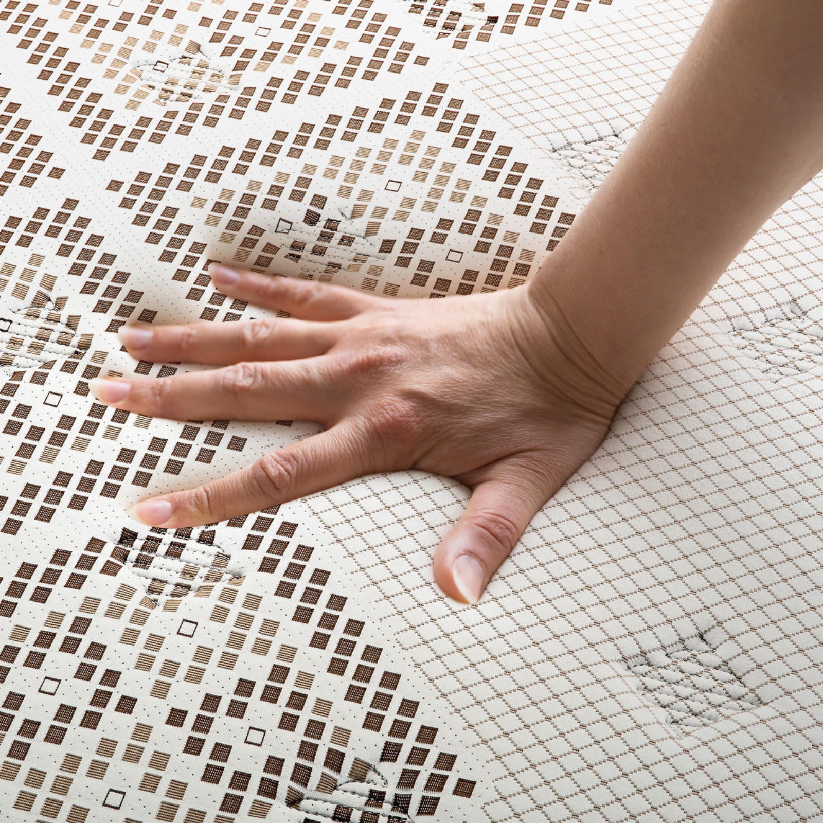 Hand pressing into the Thalia Double 30cm Memory Foam Pocket Spring Mattress, showcasing its medium firm feel and grid-patterned cover, highlighting the mattress's pressure-relieving and supportive properties.