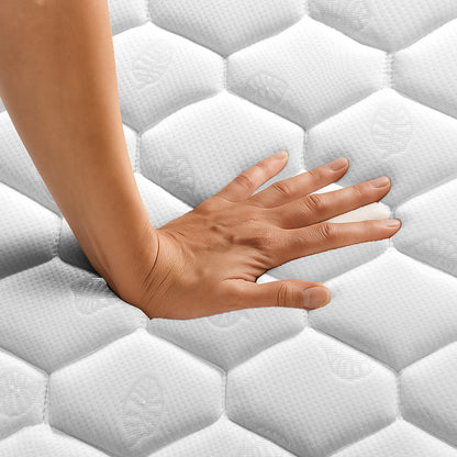 Close-up of a hand pressing down on the Thermis Single 15cm Hypoallergenic Mattress in Medium Firm, highlighting its hexagon-patterned, quilted surface and responsive memory foam cushioning layer.