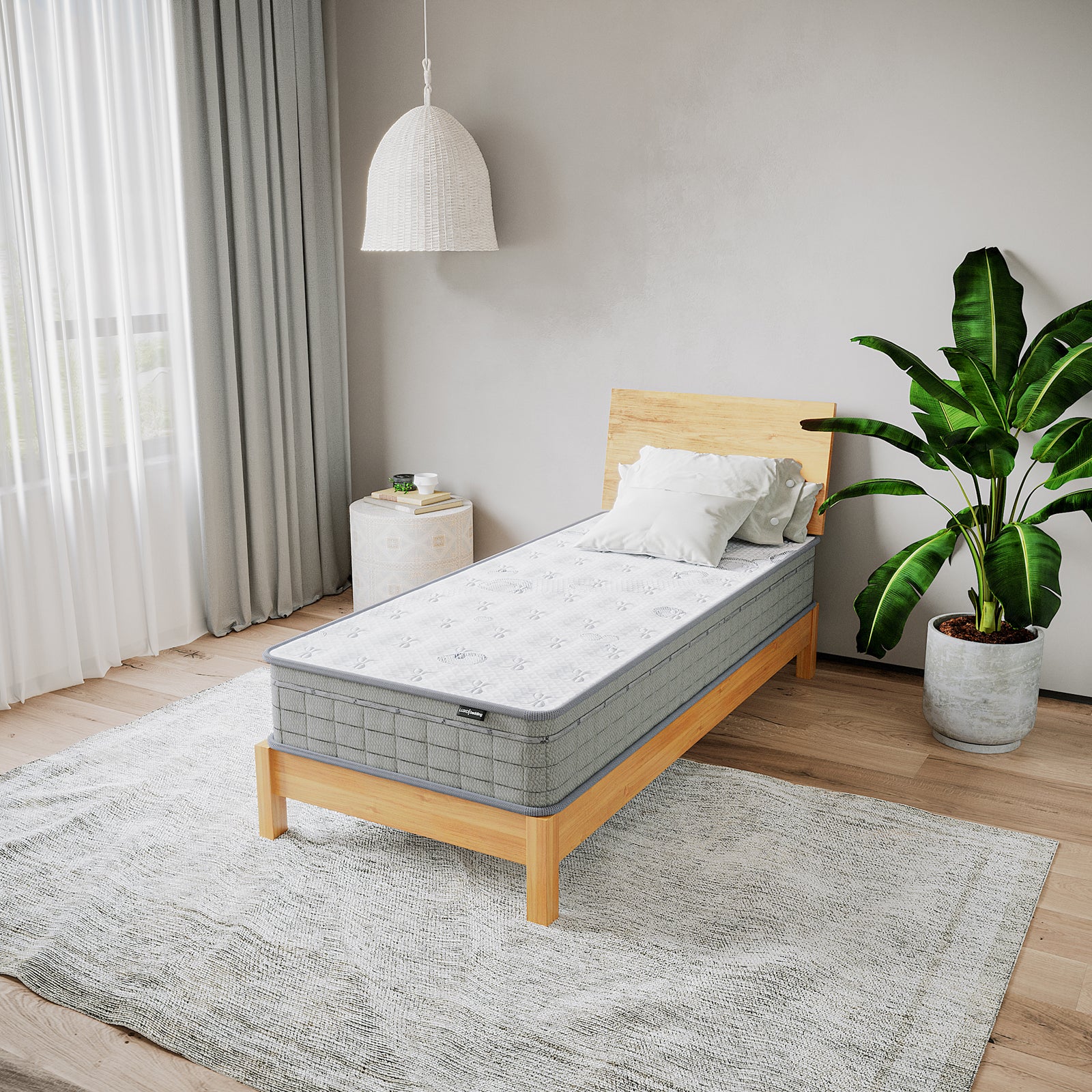 Thetis Single 25cm Pocket Spring Latex Mattress in Med Firm displayed on a minimalist bed with a light wood frame, surrounded by a cozy bedroom setting featuring a bedside stool and large potted plant.