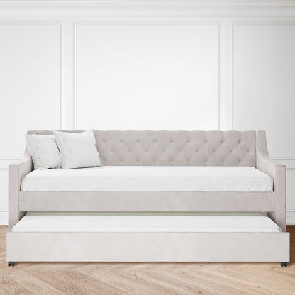 Ovidia Single Velvet Daybed Sofa with Trundle in Light Grey, featuring a tufted backrest, squared arms, and matching pillows. Pull-out trundle beneath, on herringbone wood floor against a white paneled wall.