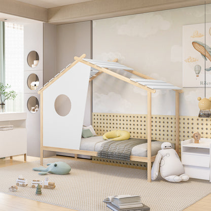 House-shaped Quinta Single Solid Pine Wood Kids Bed with wooden beams and white panels, featuring a gray mattress, check-patterned throw, and yellow crescent cushion in a minimalist, playful children's room.