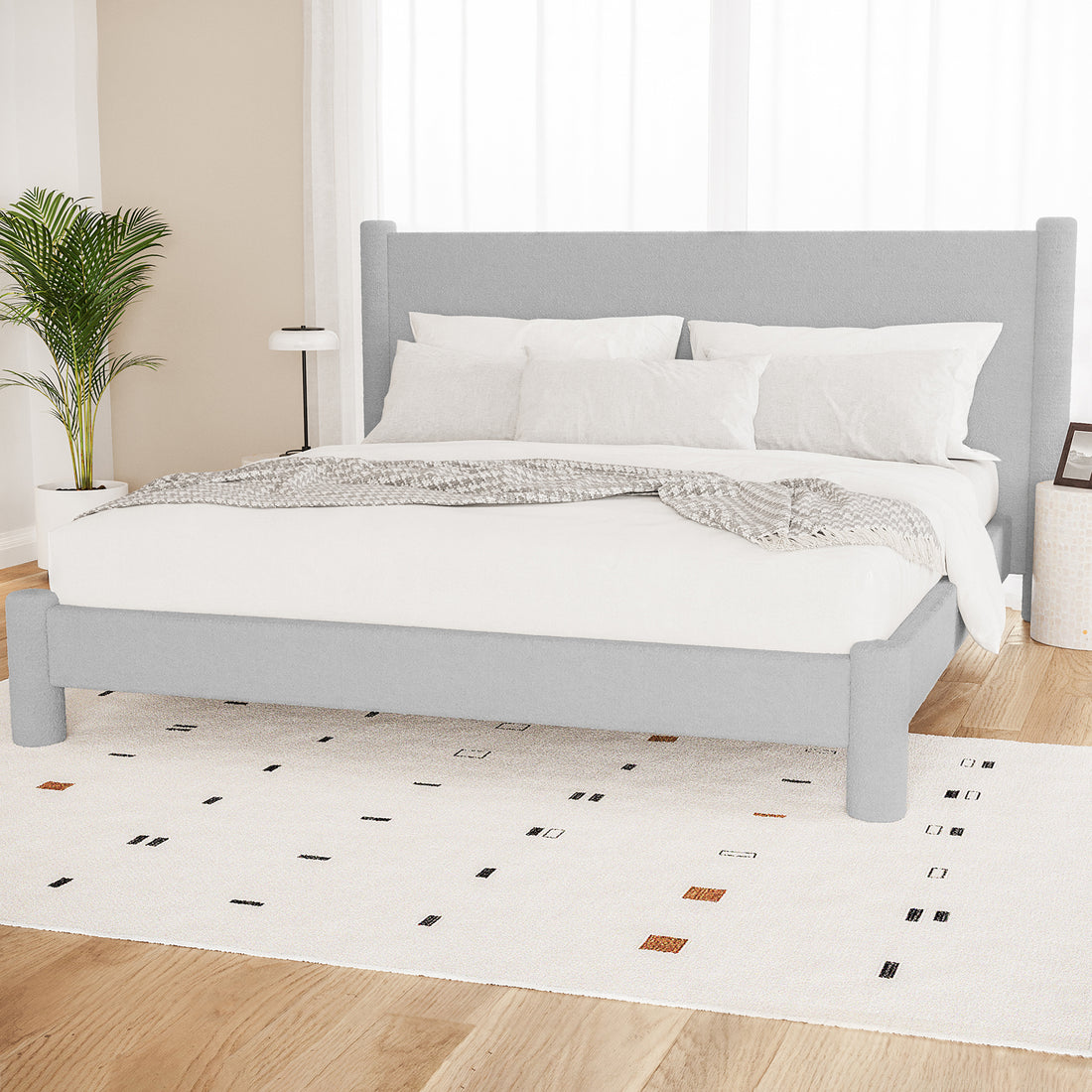 Rhoda King Boucle Fabric Bed Frame in Light Grey features a tall padded headboard, upholstered frame, white bedding, pale-grey throw, abstract rug, and minimalist decor in a serene bedroom setting.