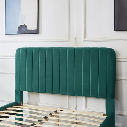 Seneca Upholstered Velvet Bed - Green Double with a tall, vertical-stitched headboard, partially assembled, showing wooden slats extending from the headboard, set against a white paneled wall.