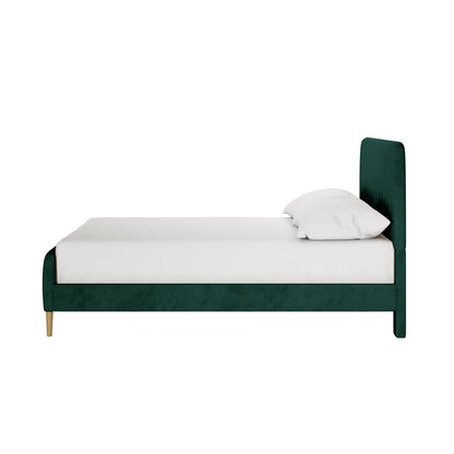 Seneca Upholstered Velvet Bed - Green Double, showcasing a side view with a teal-green velvet base, headboard, and light wood legs, complemented by a white mattress and pillows.