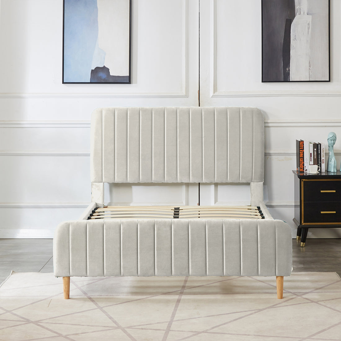 Seneca Double Upholstered Velvet Bed – Slate features a tall, channel-tufted headboard and footboard in pale fabric, light-wood legs, and exposed slatted base, set in a minimalist bedroom scene.