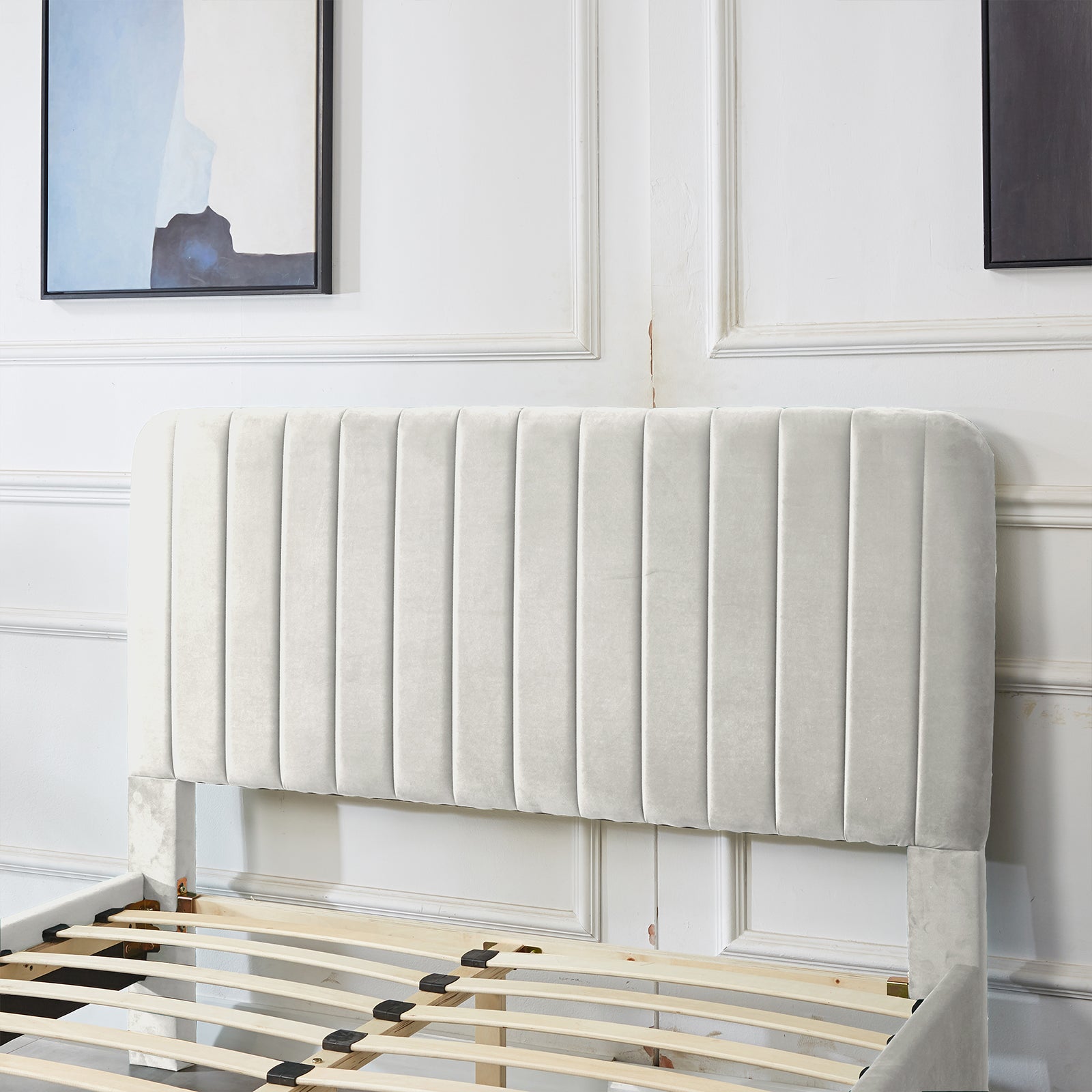 Seneca Double Upholstered Velvet Bed – Slate, showcasing a tall, curved headboard with vertical channel-tufting and fabric-wrapped legs, partially assembled with visible wooden slats against a white paneled wall.