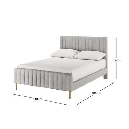 Seneca Double Upholstered Velvet Bed – Slate, featuring a light-grey, vertically channel-stitched headboard and footboard, white mattress with pillows, and slim light-wooden legs. Dimensions: 205x148x115 cm.