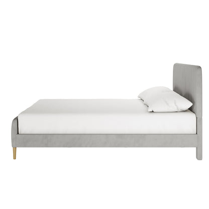 Seneca King Upholstered Velvet Bed – Slate, showcasing a low-profile, light gray upholstered frame and headboard with vertical stitching, white mattress, and pillow, on short wooden legs.