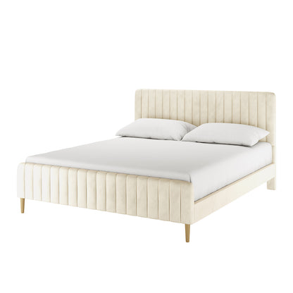 Seneca King Upholstered Velvet Bed – Sandy White features a vertically-channeled headboard, matching footboard in light cream velvet, white sheet, and pillows, standing on tapered wood legs.