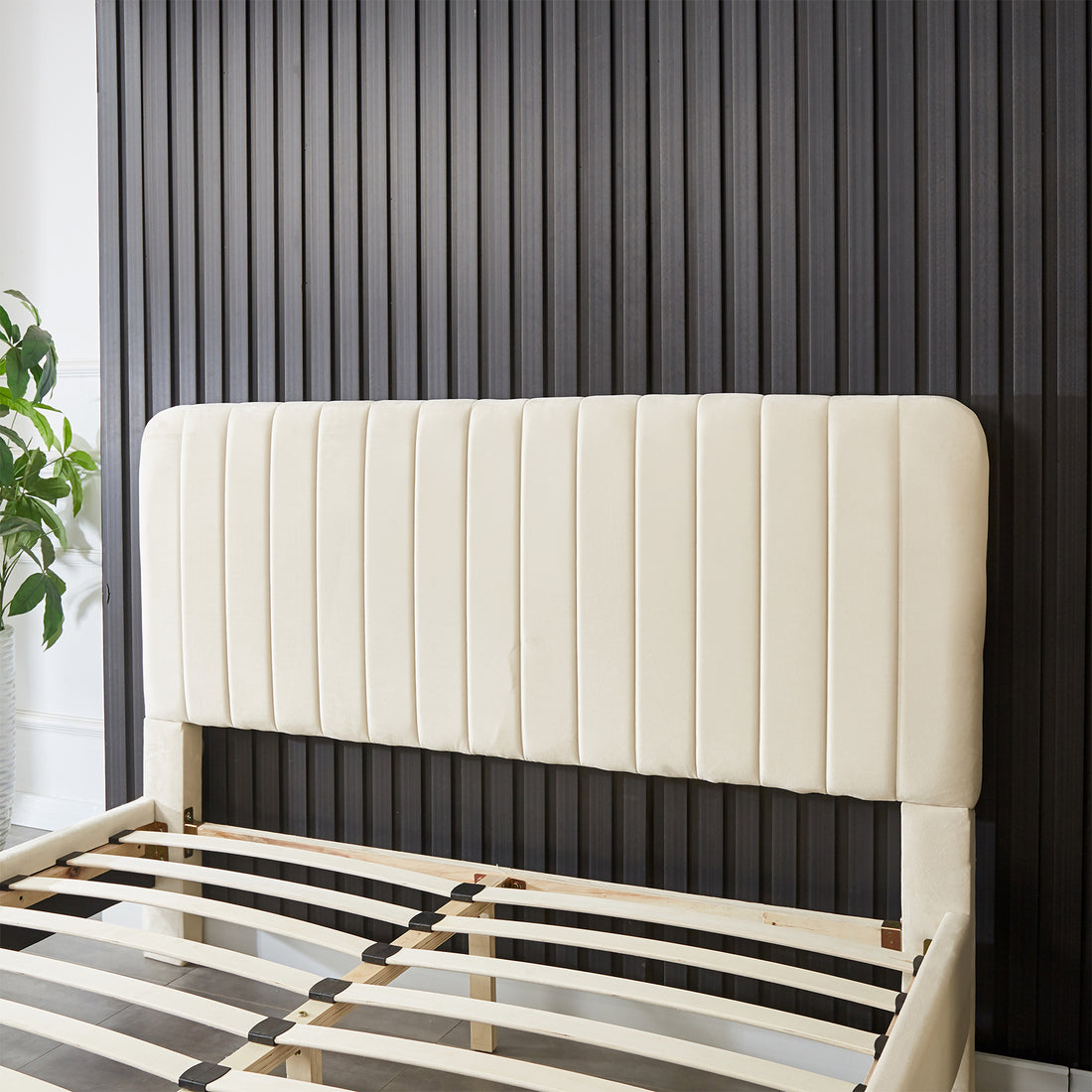 Seneca Queen Curved Velvet Fabric Bed Frame in Sandy White, featuring a tall cream upholstered headboard with vertical channeling, partly-assembled with curved wooden slats for mattress support.