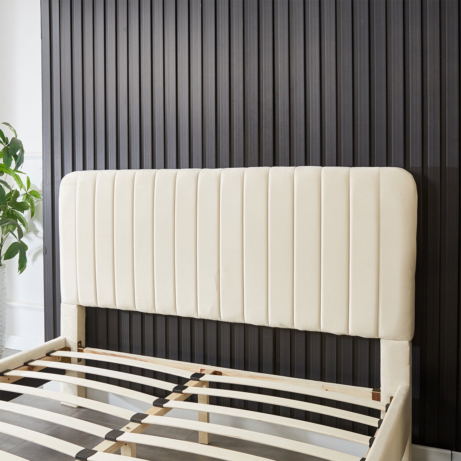 Seneca Queen Curved Velvet Fabric Bed Frame in Sandy White, featuring a tall cream upholstered headboard with vertical channeling, partly-assembled with curved wooden slats for mattress support.