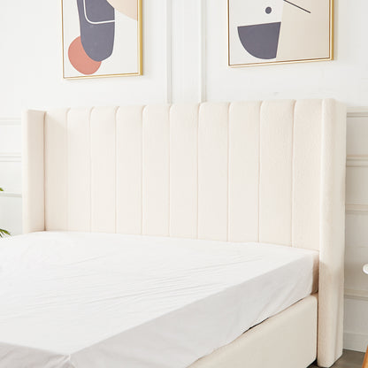 Septima & Fulvia Bouclé King Bed Base & Winged Headboard in Cream White, featuring a tall, tufted headboard and luxurious bouclé upholstery, with abstract art above and a hint of greenery beside.