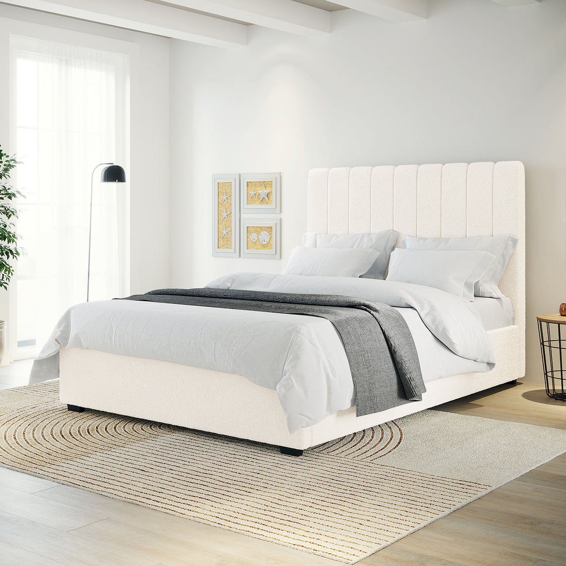 Septima & Gratiana Queen Bed Base & Headboard in Cream White features a vertically channeled, upholstered headboard. Displayed in a bright bedroom with light grey bedding, a neutral rug, and minimalist decor.