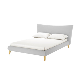 Silvina Queen Upholstered Boucle Bed in Light Grey features a gently curved headboard, light gray fabric, white mattress, and two pillows, standing on four short, tapered wooden legs.
