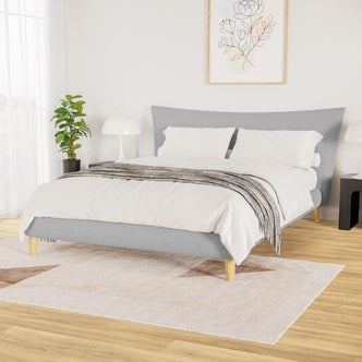 Silvina Queen Upholstered Boucle Bed in Light Grey centered in a minimalist bedroom, showcasing its grey fabric, wooden legs, and puffy headboard, complemented by white bedding and a light grey throw.