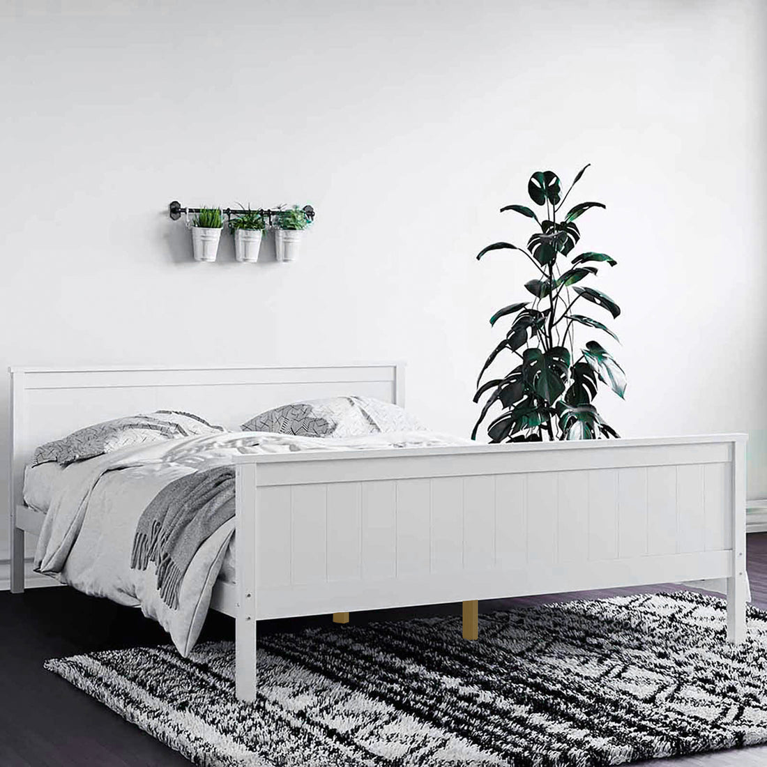 Close-up of the Tertia Solid Pine Timber Bed Frame Queen, showcasing its sturdy construction and elegant design, complemented by a black and white carpet underneath and a potted plant nearby.