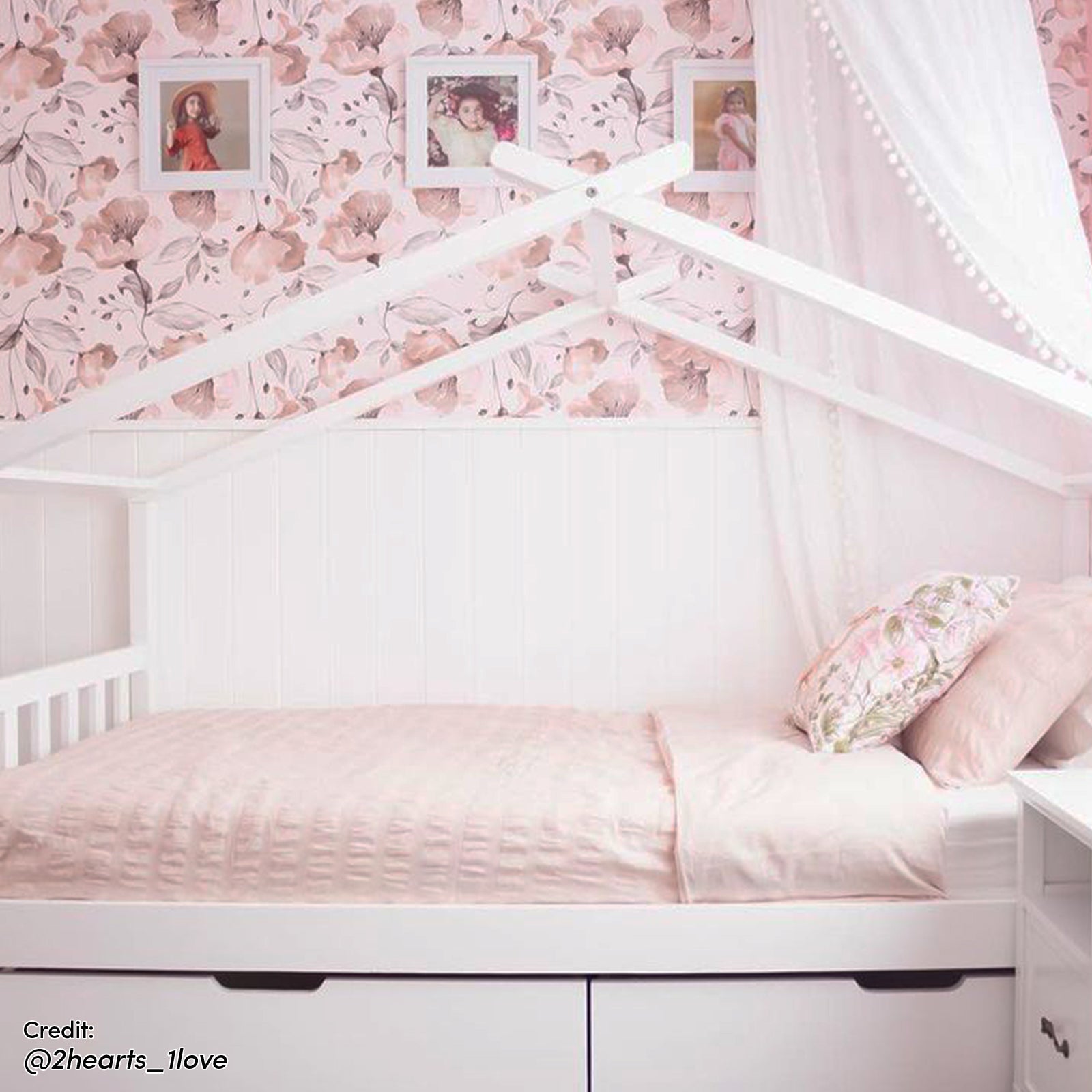 Tucker Solid Pine Timber Kids Bed with Drawers White, featuring a house-frame design with built-in storage drawers, floral-patterned bedding, and a sheer canopy, creating a cozy nursery corner.