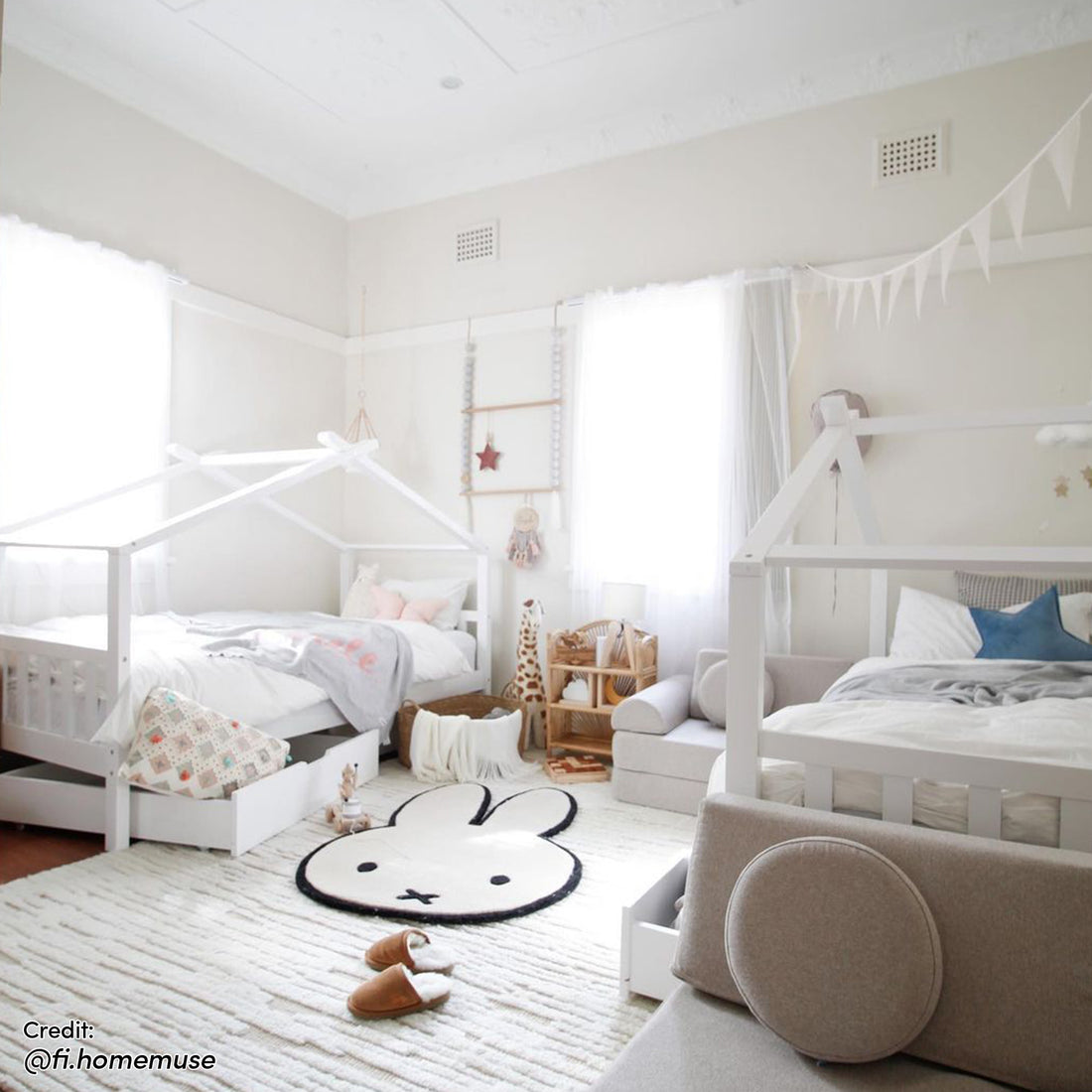 Tucker Solid Pine Timber Kids Bed with Drawers White, shown with a house-shaped frame and two under-bed storage drawers, nestled in a serene, Scandinavian-inspired children's room with playful decor elements.