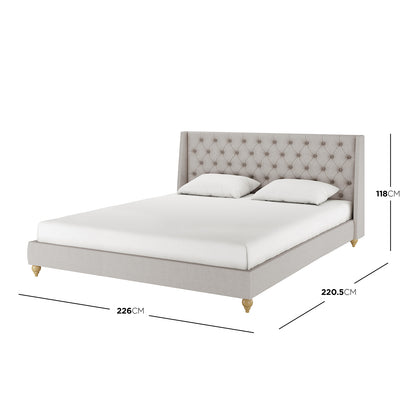 Vilania Tufted Fabric Bed Frame - Super King - Grey, featuring a prominent tufted headboard, visible on a bed with white pillows and sheets, highlighting its elegant design and luxurious grey fabric upholstery.