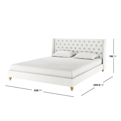 Vilania Tufted Fabric Bed Frame - Super King in off white, featuring a winged, button-tufted headboard, two accent pillows, and turned wooden legs, offering an elegant, upholstered platform design.
