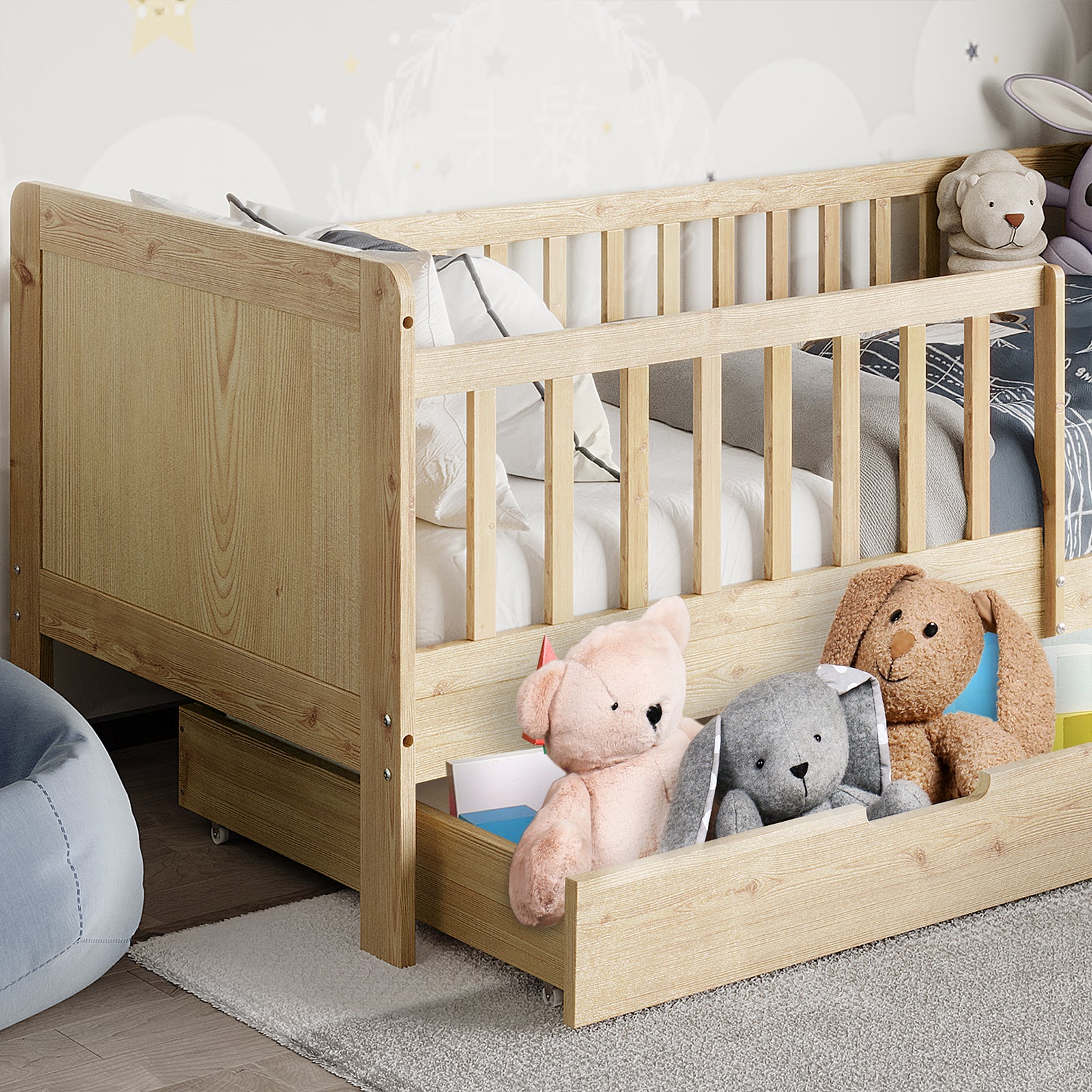 Zane Kids Solid Pine Timber Single Bed w/ Drawer - Natural features a light-wood frame with slatted guardrails, a white mattress, gray bedding, stuffed animals, and a pull-out trundle drawer for extra storage.