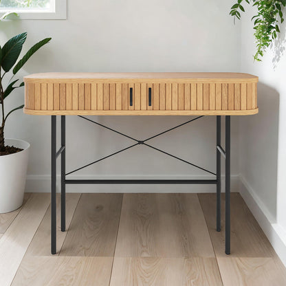 Aaron 100cm Hallway Table with Sliding Doors - Natural, featuring light-toned wood with vertical slats, black metal legs, and handles, positioned against a wall with nearby plants for a stylish entryway.