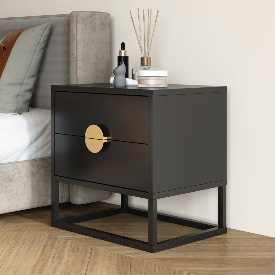 Abigail 55cm 2 Drawer Bedside Table - Black/Gold, featuring a matte black finish with gold round handles, two drawers, and an open metal base, complemented by decorative items on top.