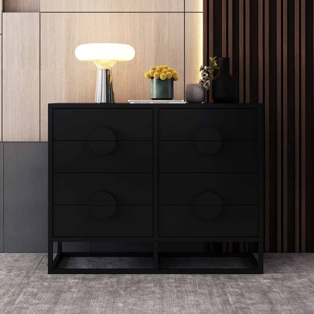 Abigail 120cm Lowboy Dresser with Drawers - Black, featuring a matte-black finish, six-drawer design on a metal frame, topped with a sculptural lamp, ceramic vessel, and vases, against wood-panelled walls.