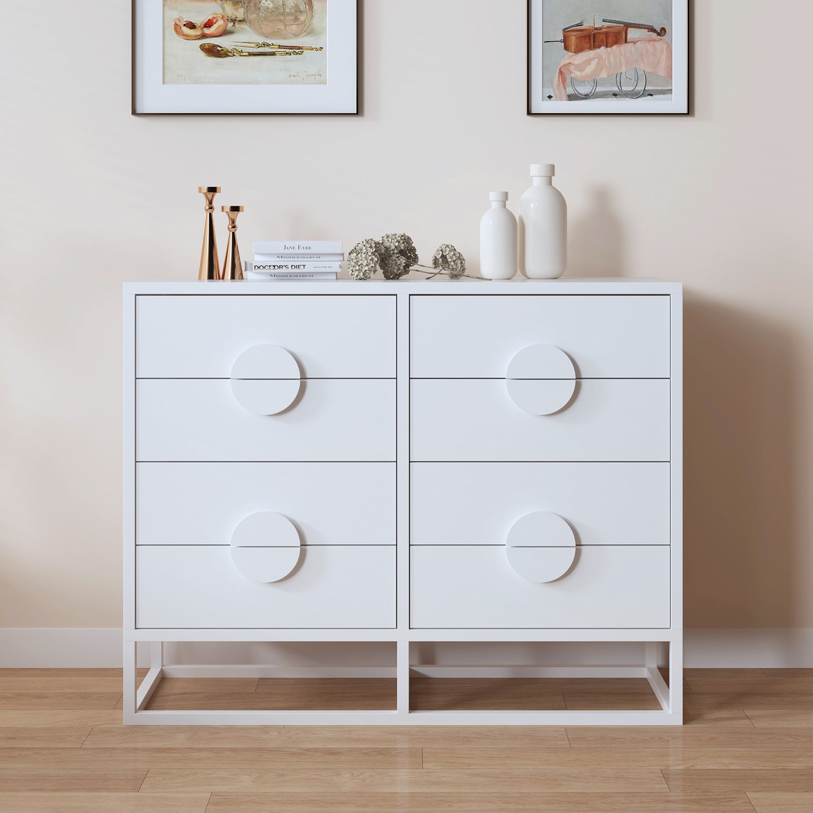Abigail 120cm Lowboy Dresser with Round Handles in White, featuring six drawers and circular pulls, sits on a wood floor with decorative objects and art prints, showcasing a minimalist, contemporary style.