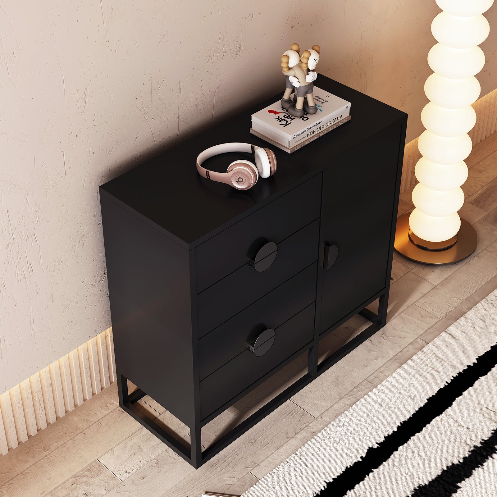 Abigail 100cm Sideboard Buffet Table - Black features a matte-black finish with three left drawers and a right cabinet. Topped with headphones, books, and an art toy, it complements a modern decor.